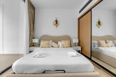 a bedroom with a large white bed and a mirror at 1 Bedroom in Binghatti Lavender in Dubai