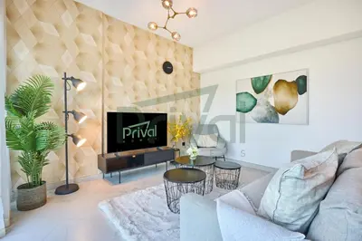 a living room with a couch and a tv at Prival - Sunlit Serenity 1BR Retreat in Dubai
