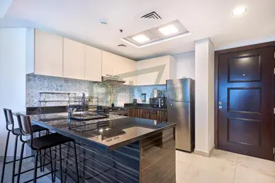a kitchen with a counter and a refrigerator at Prival - Sunlit Serenity 1BR Retreat in Dubai
