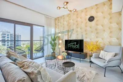 a living room with a couch and a tv at Prival - Sunlit Serenity 1BR Retreat in Dubai
