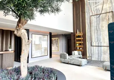 a living room with a tree and a couch at Bespoke Holiday Homes - Stylish 2BR in Oxford 212 JVC in Dubai