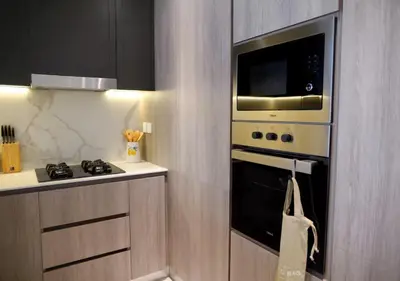 a kitchen with a stove and a microwave at Bespoke Holiday Homes - Stylish 2BR in Oxford 212 JVC in Dubai