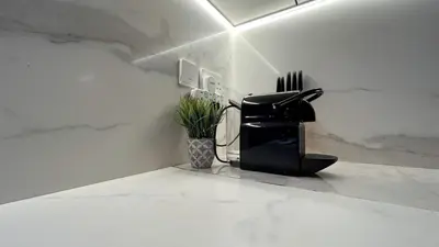 a black appliance sitting on a counter with a plant at Bespoke Holiday Homes - Stylish 2BR in Oxford 212 JVC in Dubai