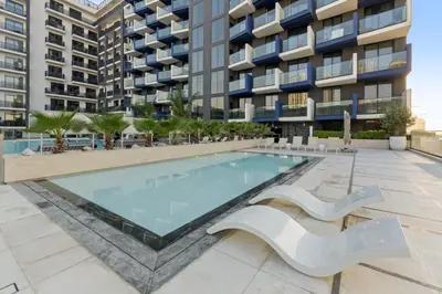 a swimming pool in front of a building at Stylish 1BR w Skyline Views & Balcony in Dubai