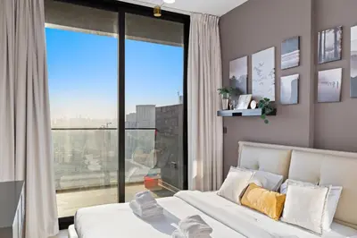 a bedroom with a bed and a large window at Stylish 1BR w Skyline Views & Balcony in Dubai