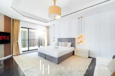 a bedroom with a white bed and a large window at LUX The Al Seef Marina 4 bed Suite in Dubai
