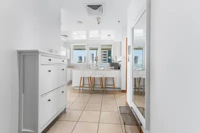 a kitchen with white cabinets and a table with chairs at Stylish 1BR in Marina, Balcony Near JBR in Dubai
