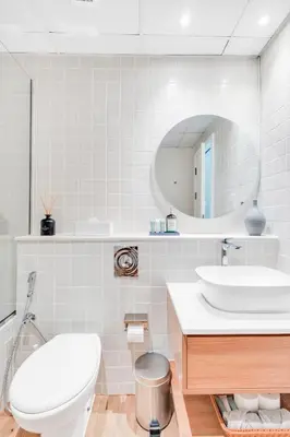 a bathroom with a toilet and a sink and a mirror at Dubai Marina Promenade 1BR Apartment with Pool near JBR in Dubai