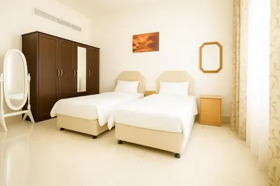 a bedroom with two beds and a mirror at Single Bed In Twin Room With Balcony For Female Guests Only in Dubai