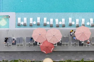 a group of umbrellas on a patio next to a pool at Cosy Studio, 7-min walk Burj Khalifa and Dubai Mall in Dubai