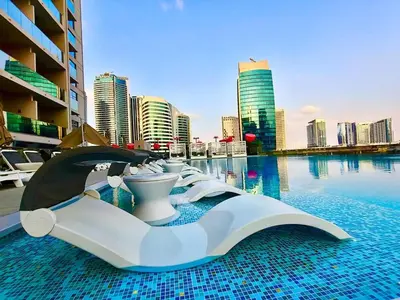 a hotel swimming pool with a view of a city at Cosy Studio, 7-min walk Burj Khalifa and Dubai Mall in Dubai