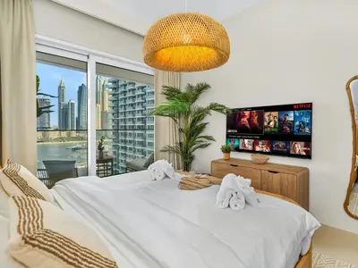 a bedroom with a white bed with a large window at Luxury Spacious 2 Bedroom Private Beach and Views in Dubai