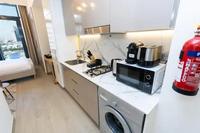 a kitchen with a stove and a microwave on a counter at CitiHome - Studio Azizi Riviera in Dubai