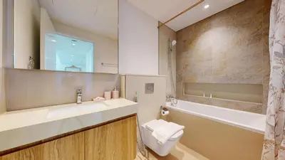 a bathroom with a sink and a toilet and a tub at Downtown Views 3 - Chic One Bed with City Views in Dubai