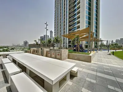 a park with white benches and a tall building at Downtown Views 3 - Chic One Bed with City Views in Dubai