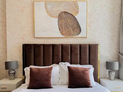 a bed with a brown headboard in a bedroom at Bronzite 2-Bed Apt Central Dubai Canal Views in Dubai