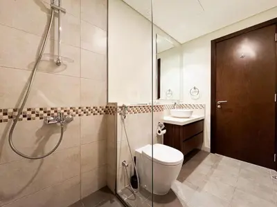 a bathroom with a shower and a toilet and a sink at Bronzite 2-Bed Apt Central Dubai Canal Views in Dubai