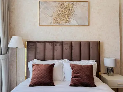 a bed with a brown headboard and two pillows at Bronzite 2-Bed Apt Central Dubai Canal Views in Dubai
