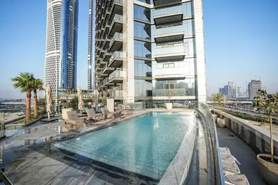 a swimming pool in front of a tall building at QUARTZ Luxe 1-Bed at Nobles Tower, Near Downtown in Dubai