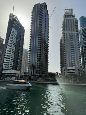 a boat in the water in front of tall buildings at Dubai Marina No 9 in Dubai