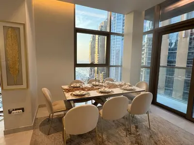 a dining room with a table and chairs and a large window at Dubai Marina No 9 in Dubai