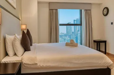 a bedroom with a large bed with a large window at Premium 3BR Downtown Retreat with Pool & Iconic Burj Views in Dubai