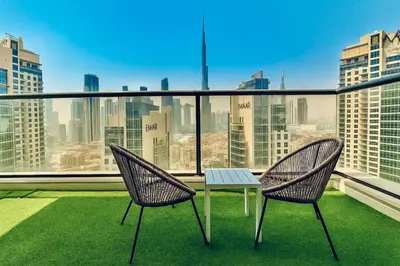 two chairs and a table on a balcony with a view at Premium 3BR Downtown Retreat with Pool & Iconic Burj Views in Dubai