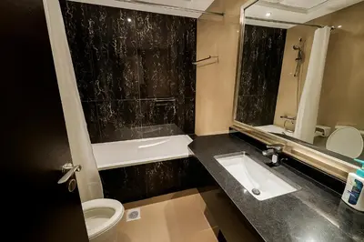 a bathroom with a sink and a toilet and a mirror at Premium 3BR Downtown Retreat with Pool & Iconic Burj Views in Dubai