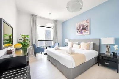 a bedroom with a large bed with a desk and a table at Luxury JBR 2BR Shams Full Marina View Free 5 Star Beach Resorts Access in Dubai