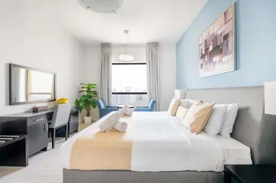 a bedroom with a large bed and a desk at Luxury JBR 2BR Shams Full Marina View Free 5 Star Beach Resorts Access in Dubai
