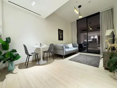 a living room with a table and a couch at DVR 1BR Apartment Available in Binghatti Corner in Dubai