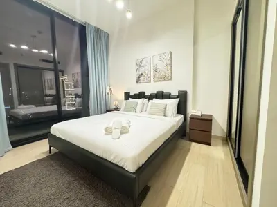a bedroom with a large bed with shoes on it at DVR 1BR Apartment Available in Binghatti Corner in Dubai