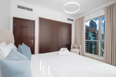a bedroom with a large bed with two wedding rings on it at LUX The Burj Khalifa Fountain View Suite 3 in Dubai