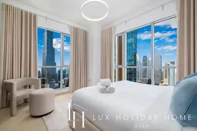 a bedroom with a white bed and a large window at LUX The Burj Khalifa Fountain View Suite 3 in Dubai