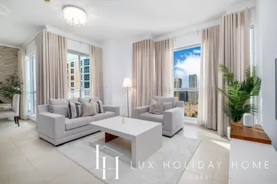 a living room with two couches and a table at LUX The Burj Khalifa Fountain View Suite 3 in Dubai
