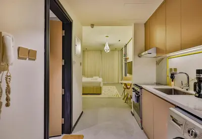a kitchen with a sink and a room with a bed at Studio Apartment in Burj View Residence, Arjan - Allsopp & Allsopp in Dubai