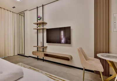 a bedroom with a bed and a tv on a wall at Studio Apartment in Burj View Residence, Arjan - Allsopp & Allsopp in Dubai
