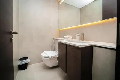 a bathroom with a white toilet and a sink at Luxury 1BR Suite - Comfort Meets Class in Dubai