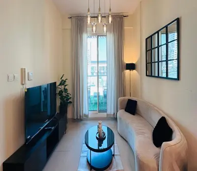 a living room with a couch and a tv at Modern 1BR w Pool and Parking At Roxana Residence in Dubai