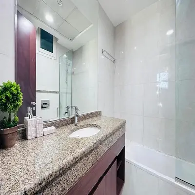 a bathroom with a sink and a shower and a tub at Modern 1BR w Pool and Parking At Roxana Residence in Dubai