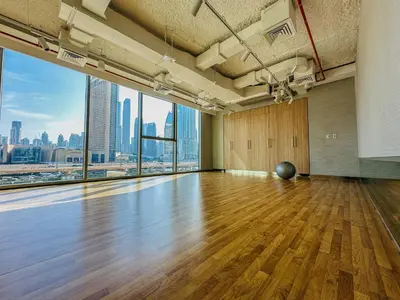a large room with a wooden floor and a large window at Luxurious 1BR High Floor Skyline View Downtown in Dubai