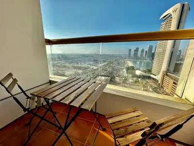 a bench on a balcony with a view of a city at Luxurious place to stay in Dubai Marina in Dubai