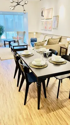 a living room with a table with chairs and a couch at Luxurious place to stay in Dubai Marina in Dubai