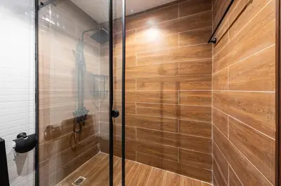 a shower with wooden walls and a glass door at Luxurious place to stay in Dubai Marina in Dubai