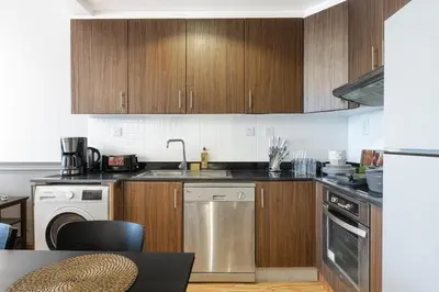 a kitchen with wooden cabinets and a sink and a dishwasher at Luxurious place to stay in Dubai Marina in Dubai