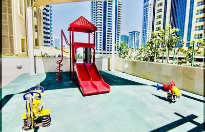 a playground with a red slide in a city at Luxurious place to stay in Dubai Marina in Dubai