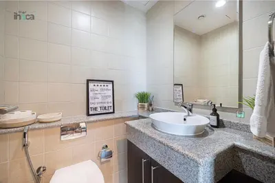 a bathroom with a sink and a toilet and a mirror at 71st Floor Luxury 1Br Spacious Skyline Balcony in Dubai