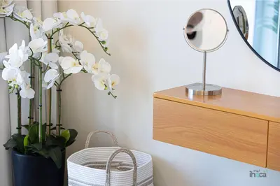 a mirror and a vase with white flowers in a room at 71st Floor Luxury 1Br Spacious Skyline Balcony in Dubai