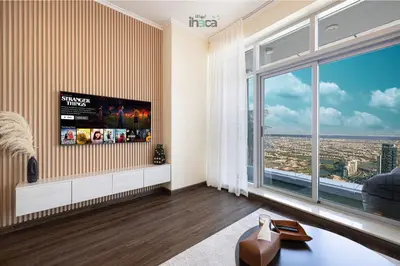 a living room with a tv and a large window at 71st Floor Luxury 1Br Spacious Skyline Balcony in Dubai