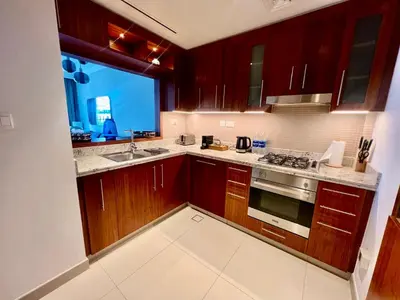 a kitchen with wooden cabinets and a sink and a window at Elegant apartment Dubai downtown in Dubai
